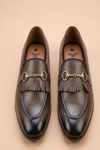 pair of chiku horsebit loafers possibly made of leather or synthetic leather,featuring a gold-tone buckle detail and fringe