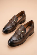 pair of chiku horsebit loafers possibly made of leather or synthetic leather,featuring a gold-tone buckle detail and fringe