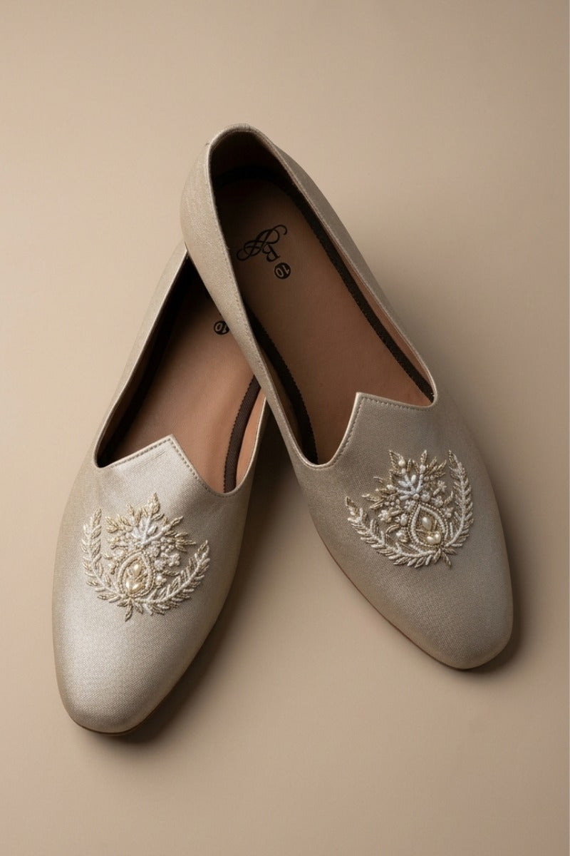 Gold  colour juttis with intricate silver and crest -inspired embroidery