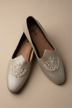 Gold  colour juttis with intricate silver and crest -inspired embroidery