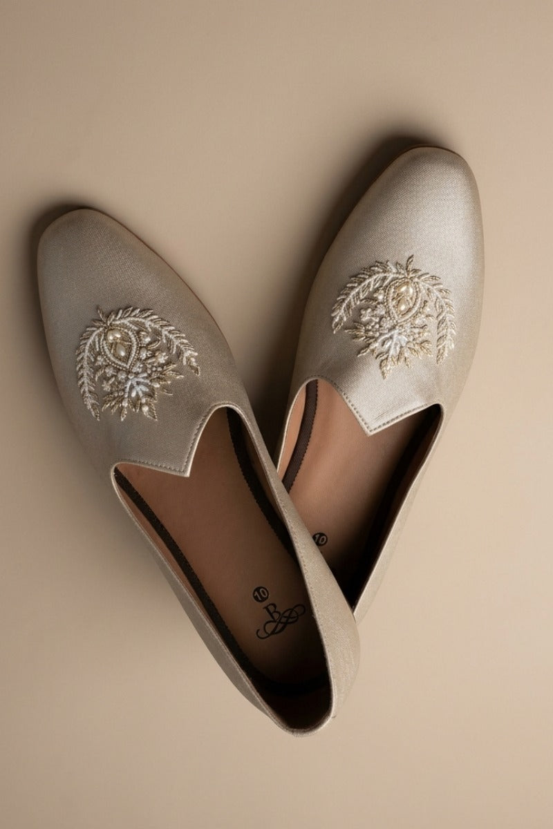Gold  colour juttis with intricate silver and crest -inspired embroidery