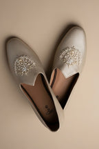 Gold  colour juttis with intricate silver and crest -inspired embroidery